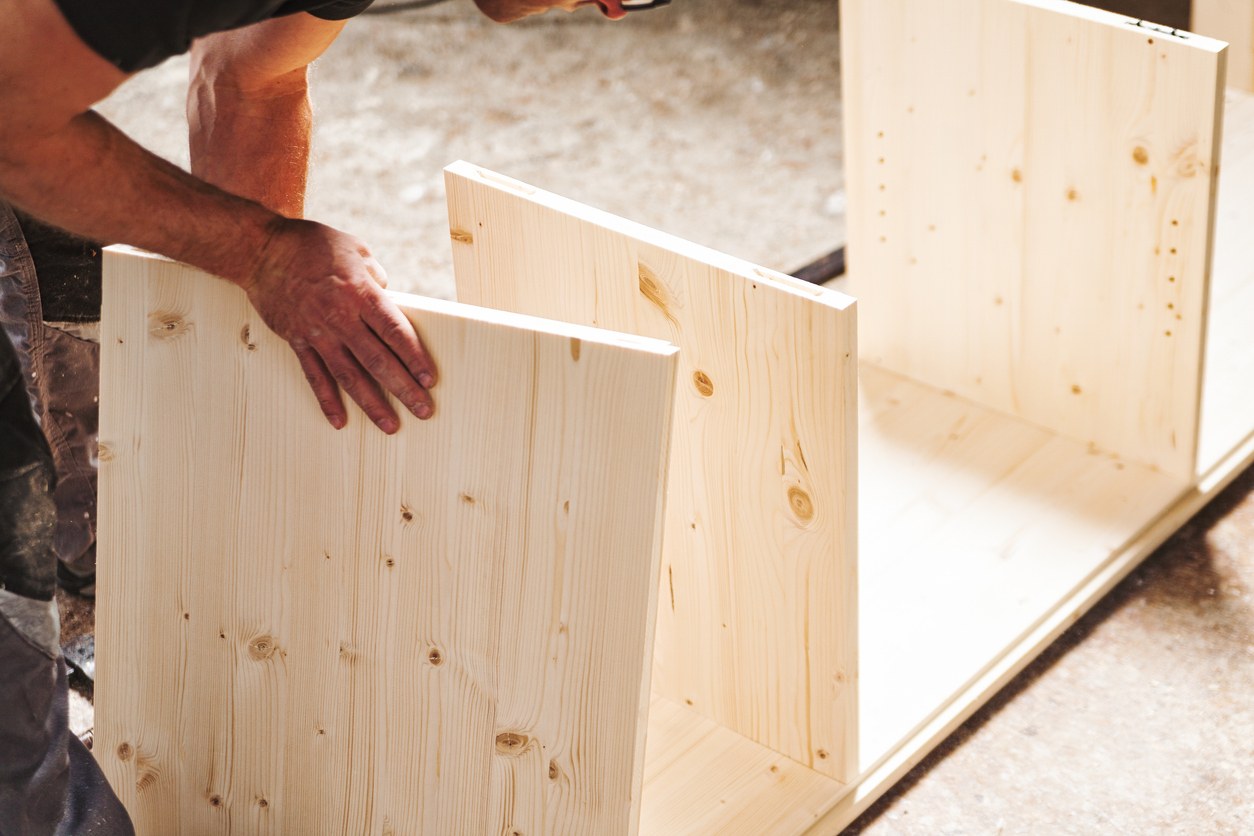 Carpenter assembling wooden furniture in workshop